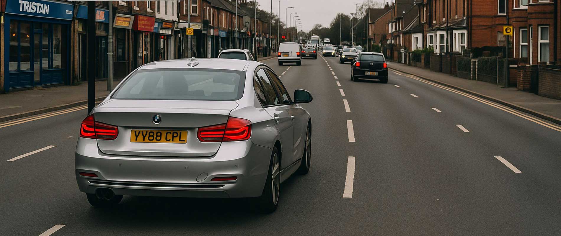 A parked car beside a row of shops in luton